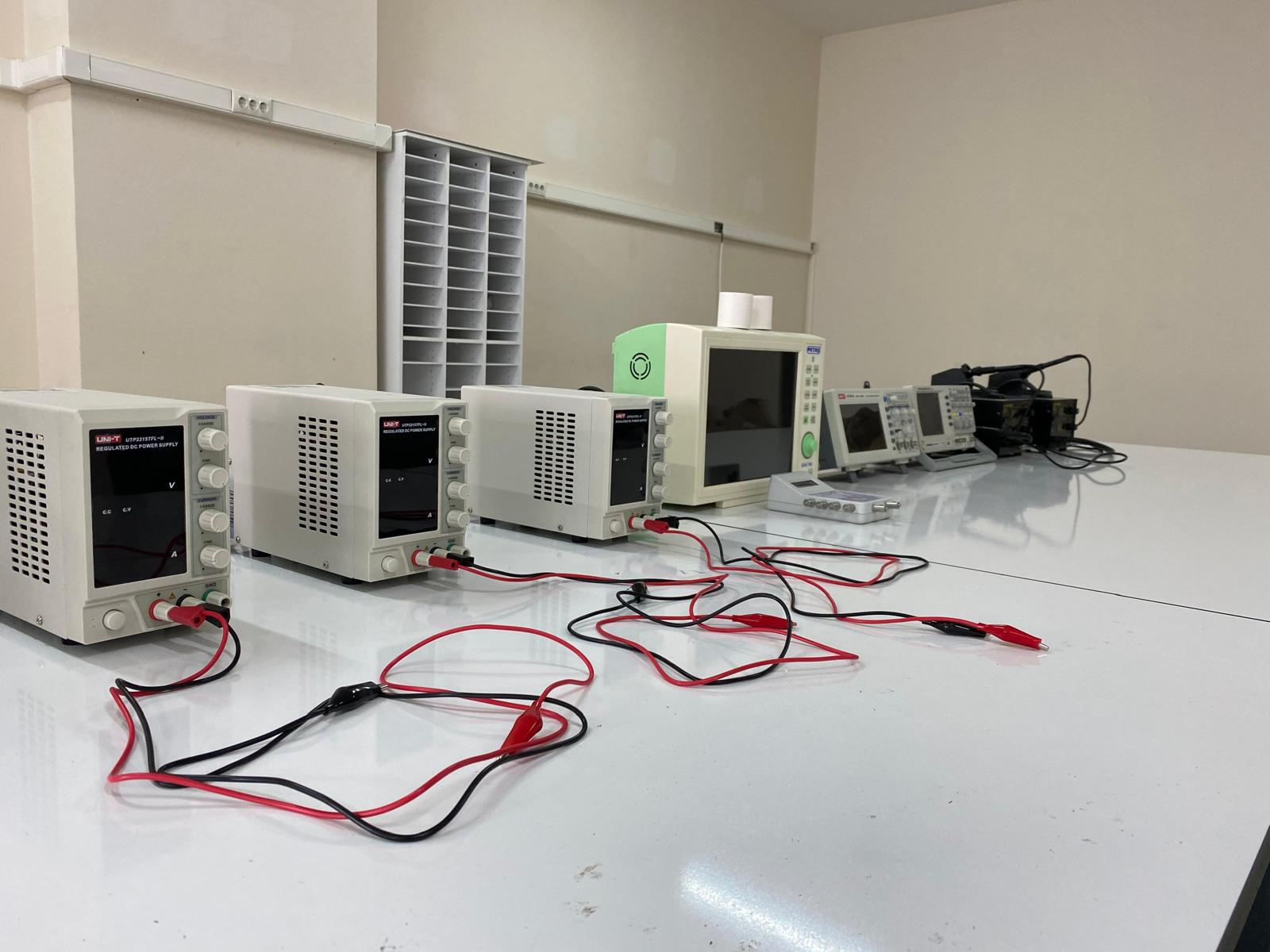 Güç kaynağı, osiloskop ve ölçüm cihazlarının bulunduğu laboratuvar masası