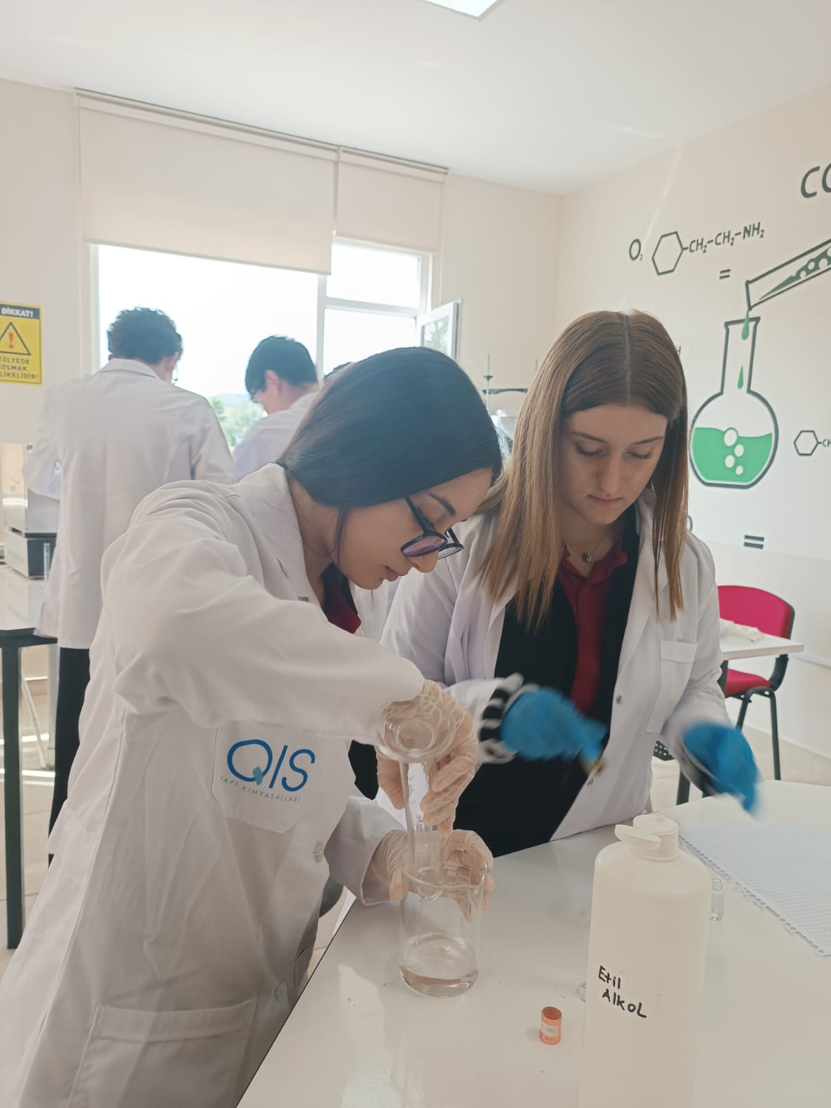 Dinamik öğrencileri Kimya laboratuvarında analiz uygulaması yaparken